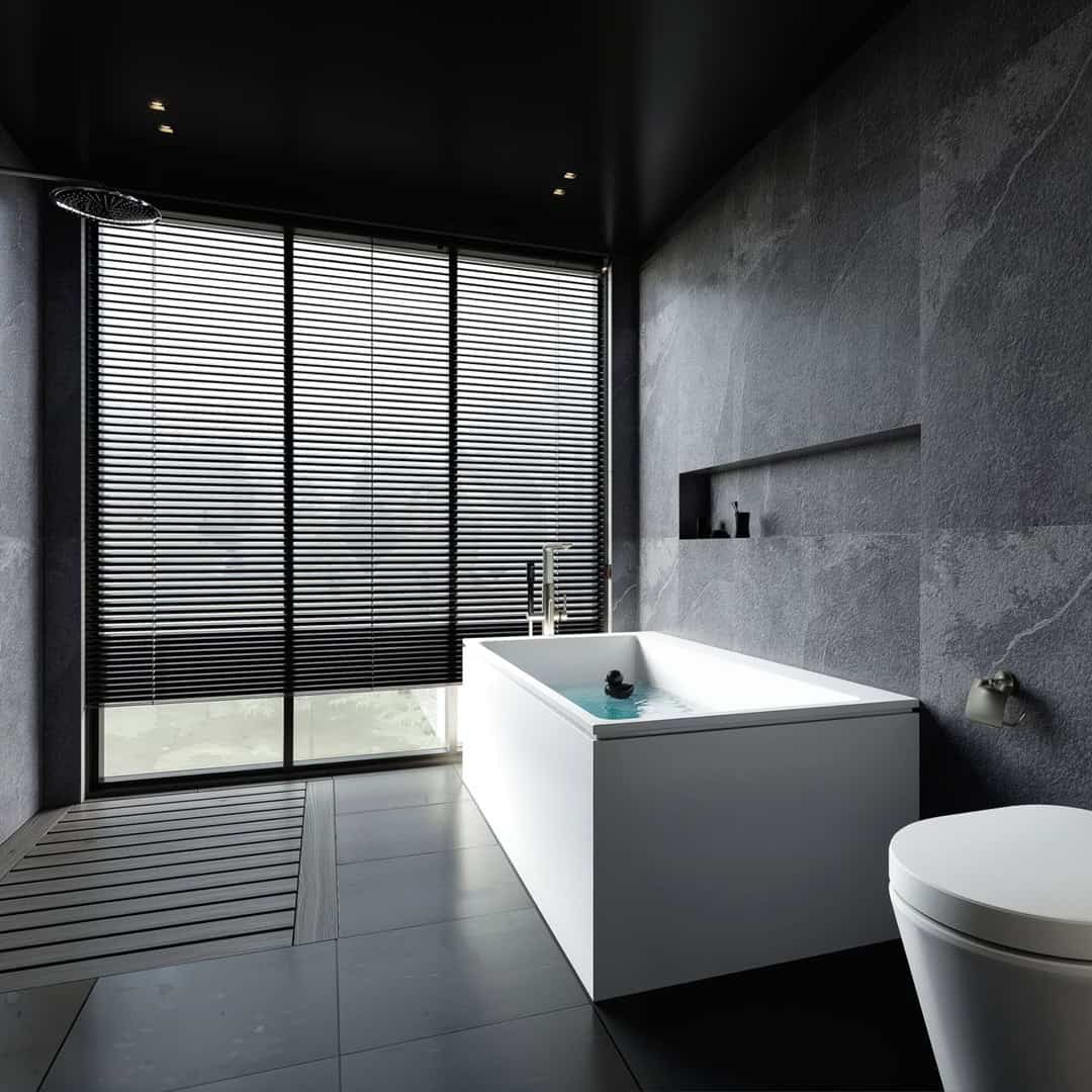 Freistehende weiße Badewanne vor einer dunklen Fliesenwand in Anthrazit für ein Projekt in Oranienburg.
