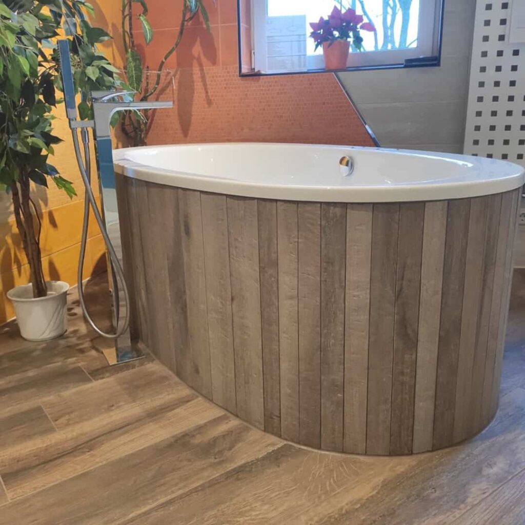 Exklusive freistehende Badewanne mit Holzoptik-Verkleidung in der Badausstellung der Fliesen Scholz GmbH in Leegebruch.